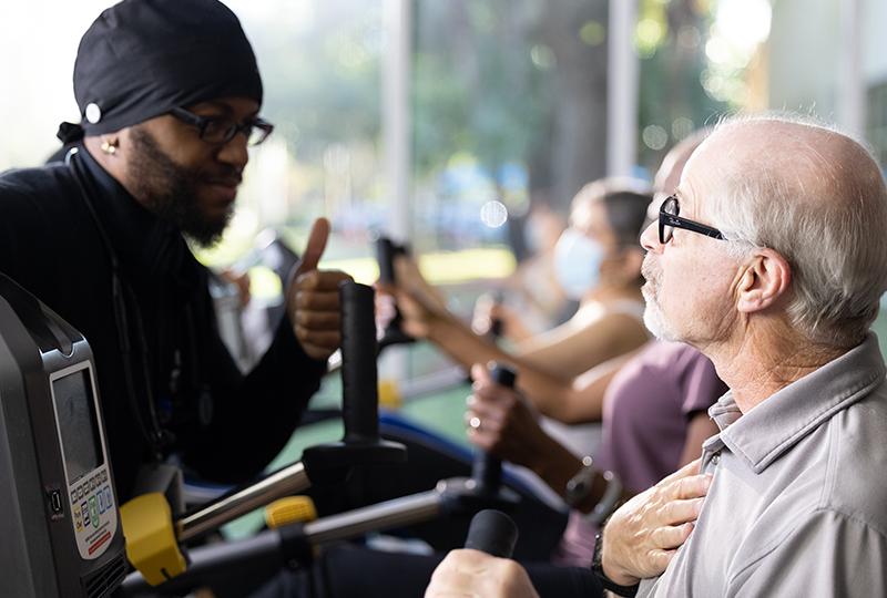 therapist giving thumbs up to patient on seated bike