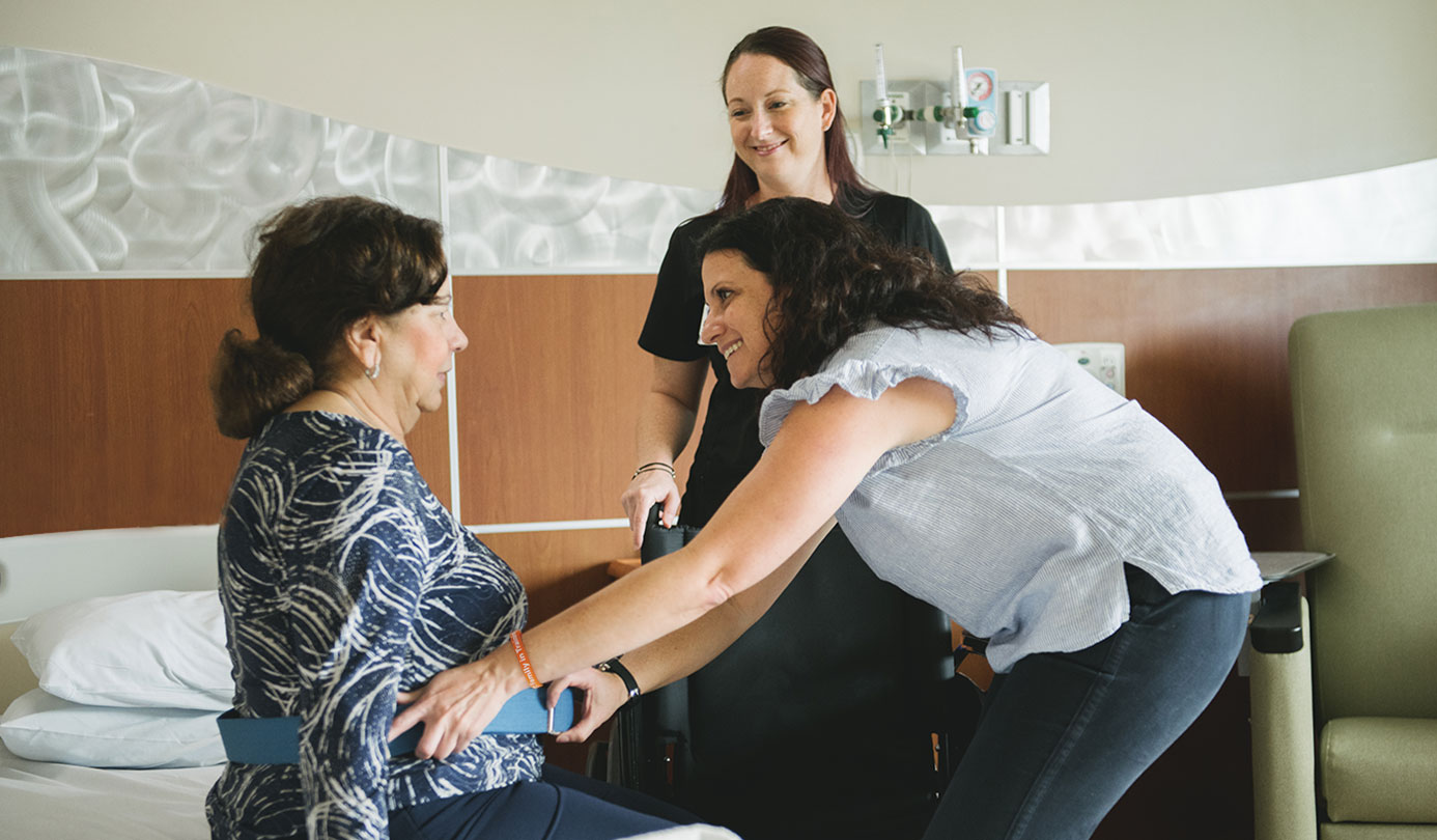 Daughter learning how to assist her mother during a Family In Training (FIT) Program session at Memorial Regional South.